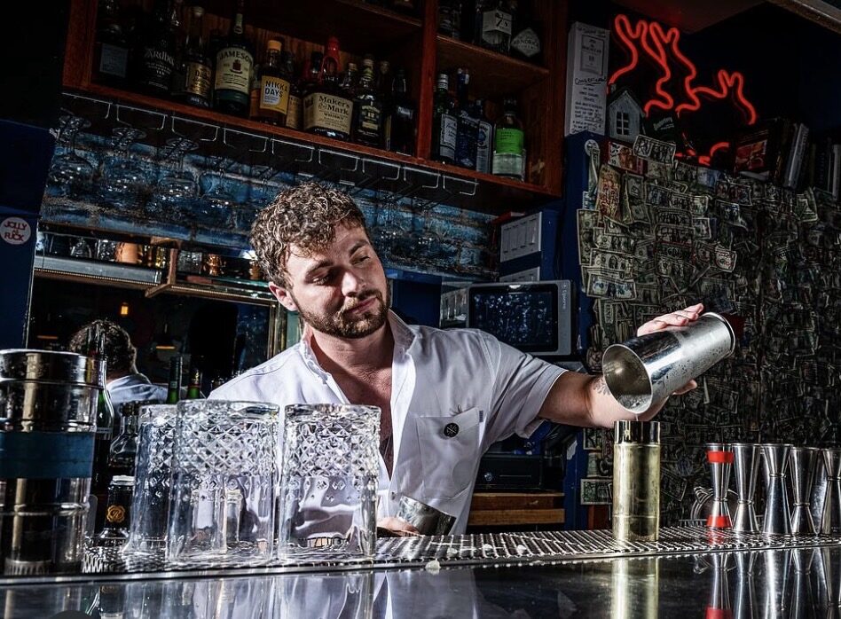 Decker behind the bar shaking a cocktail